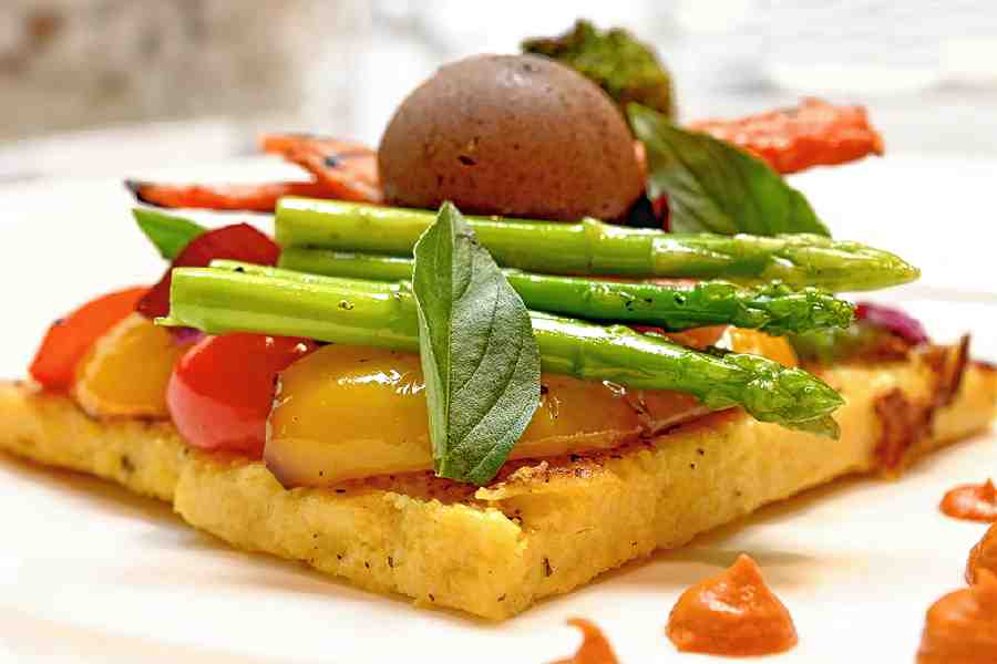 Pan-tossed Vegetables: Cooked polenta base is topped with freshly tossed veggies in different colours, cooked to just the right bite and served with black garlic butter that just marries it all together.