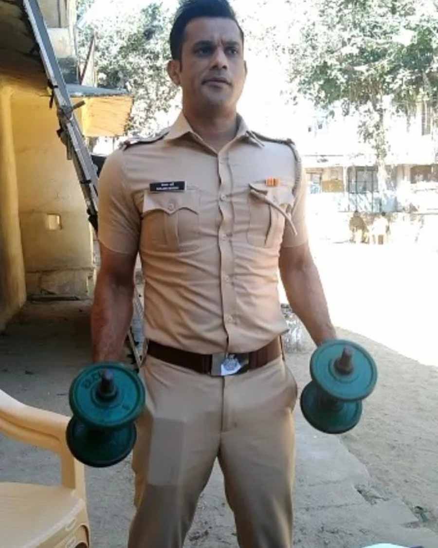 Sohum works out with a pair of dumbbells to look in shape as SI Kailash Parghi. 