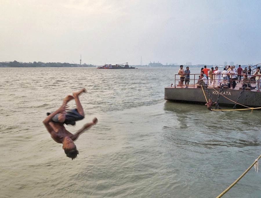 A boy jumps into Hooghly river amid the humid and unbearable weather conditions in Kolkata. According to the Indian Meteorological Department (IMD), the maximum temperature recorded on Monday was 36° Celsius. Thundershowers have been predicted between May 23 and 27   