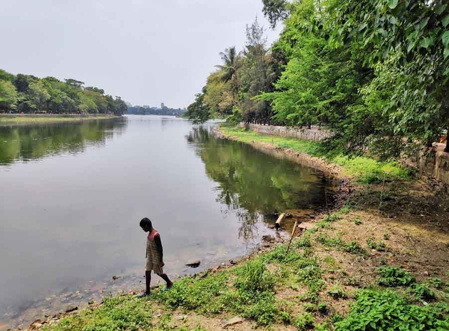 A boy walks on the edge of  Rabindra Sarobar on a sultry Tuesday afternoon. The water level of the lake has decreased drastically due to intense weather conditions    