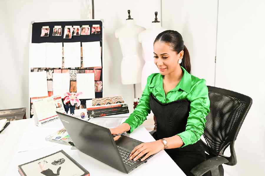 Ushoshi elevates her office look by wearing the black corset over a silky Bottega green shirt. A pair of black trousers and minimal jewellery complete the look. 