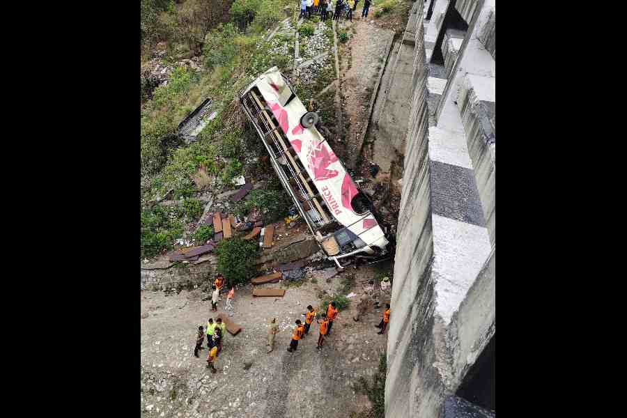 Rescue teams near the wreckage of a bus after an accident, at Jhajjar Kotli area in Jammu district