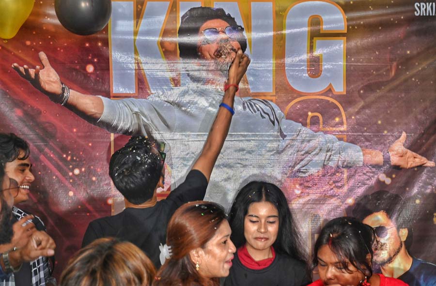 The madness surrounding SRK’s knew no bounds even as a fan was seen thrusting a slice of cake into the mouth of the image of King Khan on the banner 
