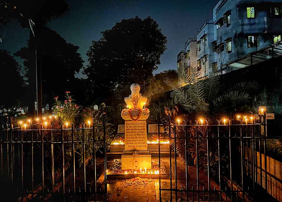 Candles let out a warm glow at the grave of poet Michael Madhusudan Dutt at the Lower Circular Road Cemetery