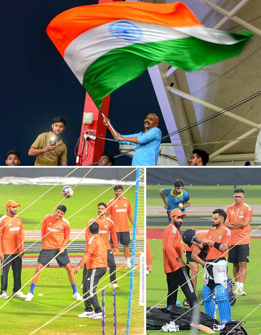 Sudhir Gautam waves the Tricolour from the stands at the Eden even as Team India players practise at the nets on Saturday