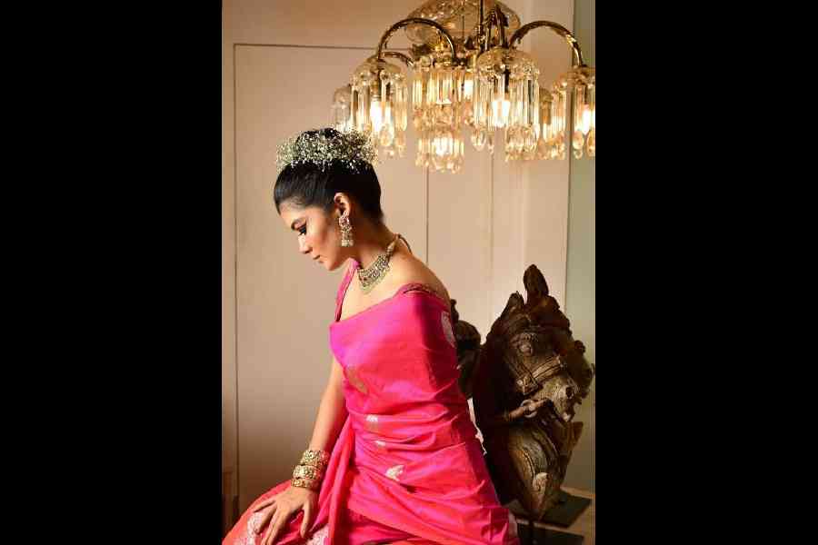 A mix of drama and tender femininity makes this dual fuchsia pink pure silk Benarasi look so beautiful. "I had not decided on a pink sari. It is only after seeing the sari that I chose to do pink. I am extremely fond of saris without a border. It’s a classic festive colour. The moment I saw the sari, I knew the look I wanted. I am sure of the drama that I want. I love flowers in my hair and I have experimented with every kind of flower, but never Baby's-breath. It looks really nice," says Roja. The bold eyes, the small bindi and elegant jewellery play perfect co-stars