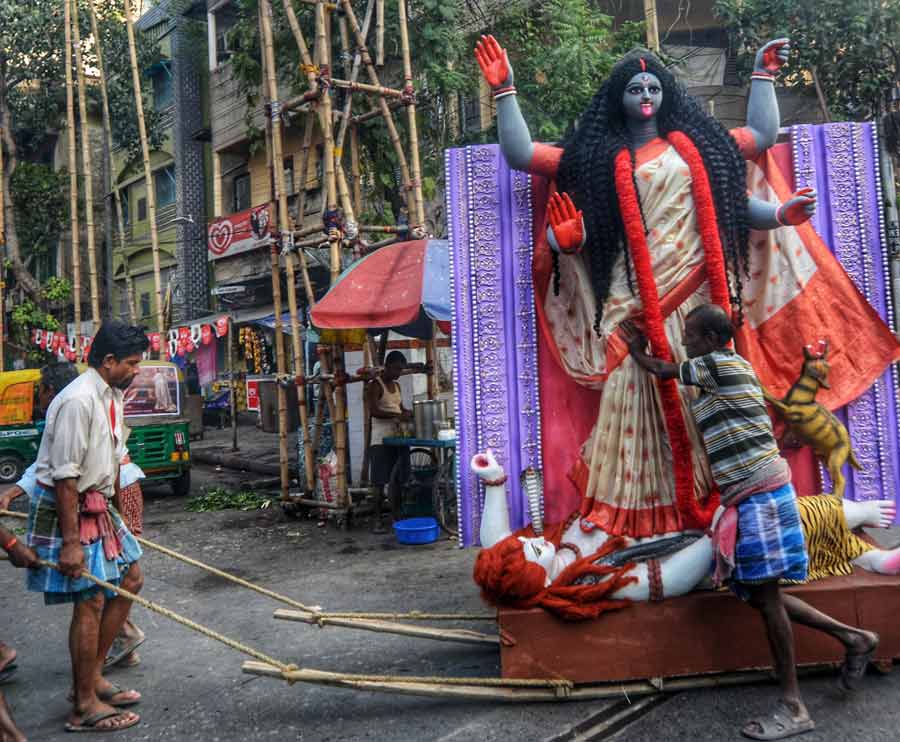 Porters carry an idol of goddess Kali from Kumartuli to a community puja pandal on Thursday