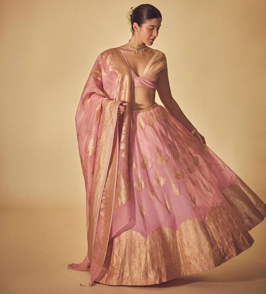 Shanaya Kapoor went for a minimal look in a light-pink lehenga with a golden border. The actress wore a golden choker and adorned her hair bun with a gajra.