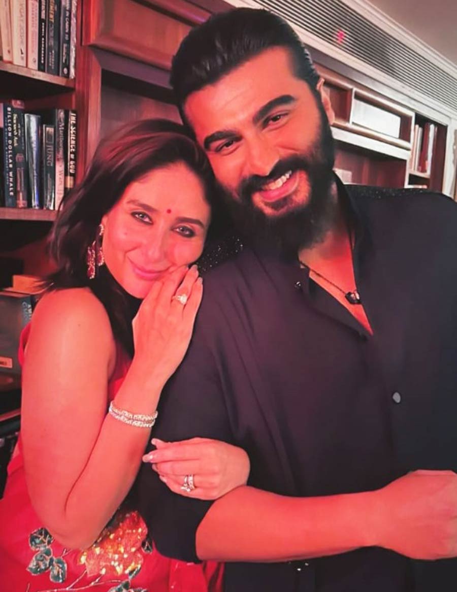 Kareena held Arjun Kapoor’s arm and posed for the camera in a red sari with floral prints. Arjun sported a black kurta.