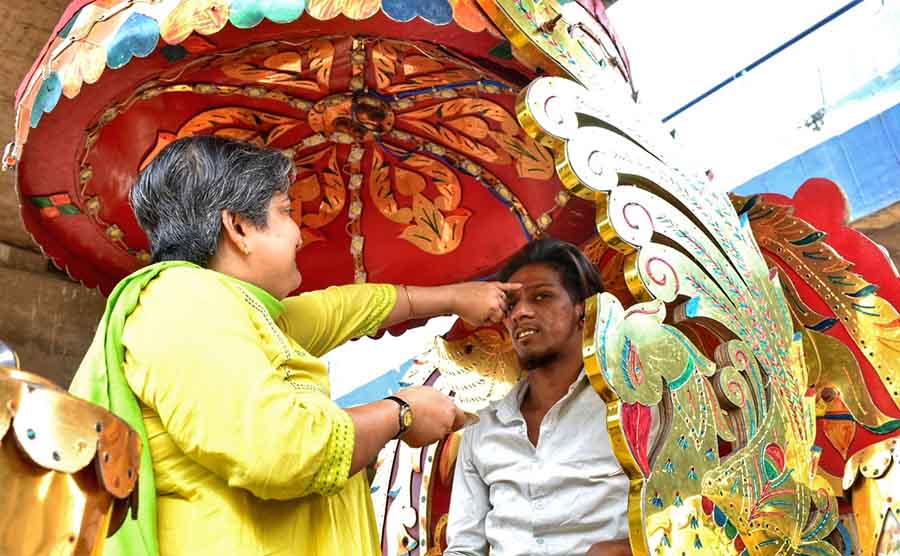 A woman applies ‘phonta’ (tilak) on a horse carriage driver at Hastings on Wednesday