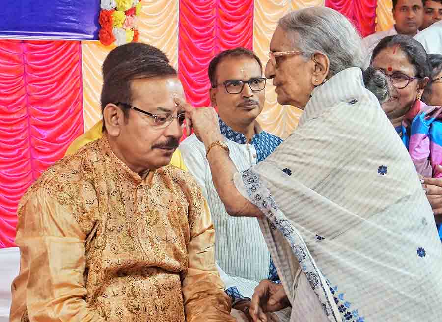 An elderly resident of the Navanir old-age home in Tollygunge applies ‘phonta’ on minister Aroop Biswas on Wednesday