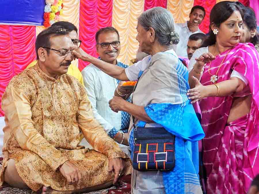 Another woman performs the ritual on the minister