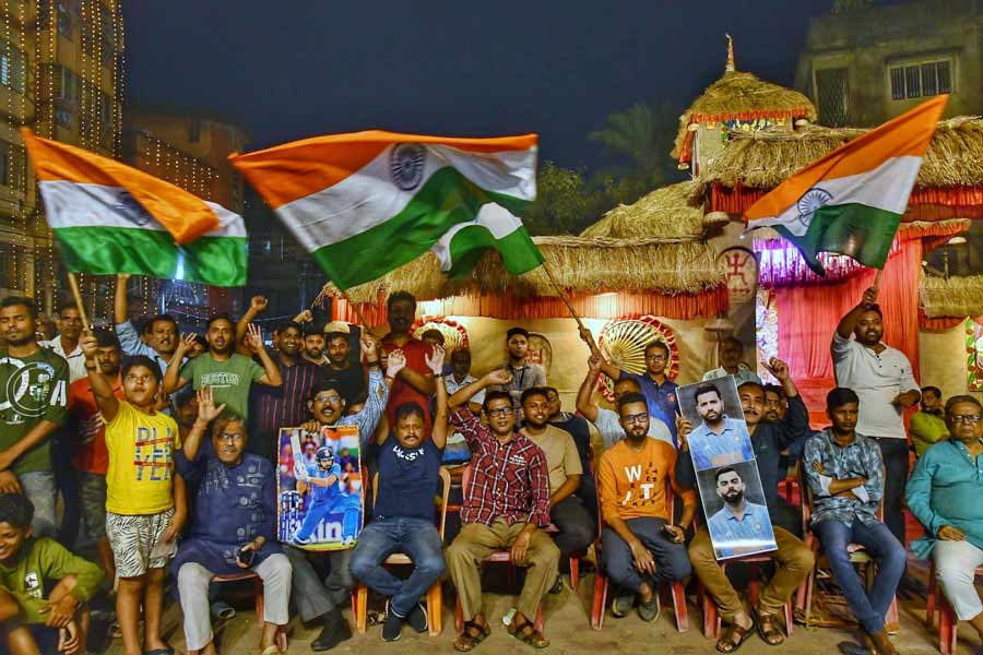 Excited fans hold posters of Virat Kohli, sway the Tricolour and pump fists in air at a local club in Baguiati