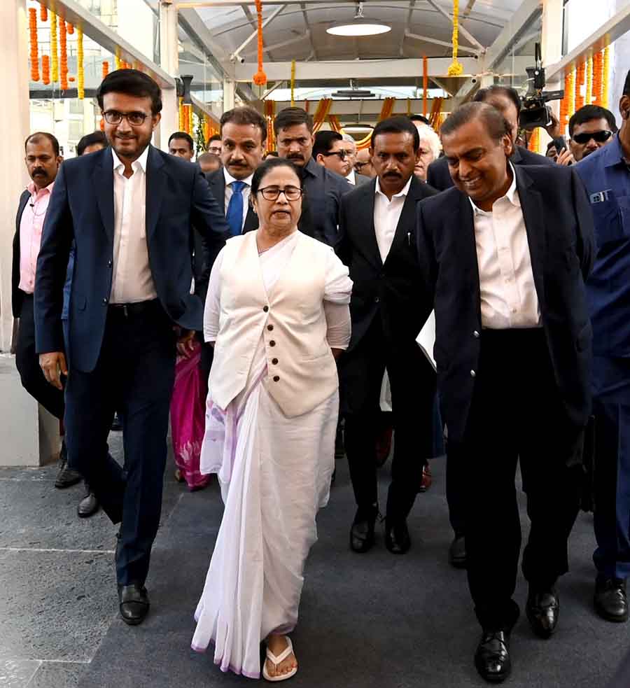 Flanked by Sourav Ganguly and Mukesh Ambani, Mamata Banerjee walks into the Biswa Bangla Convention Centre