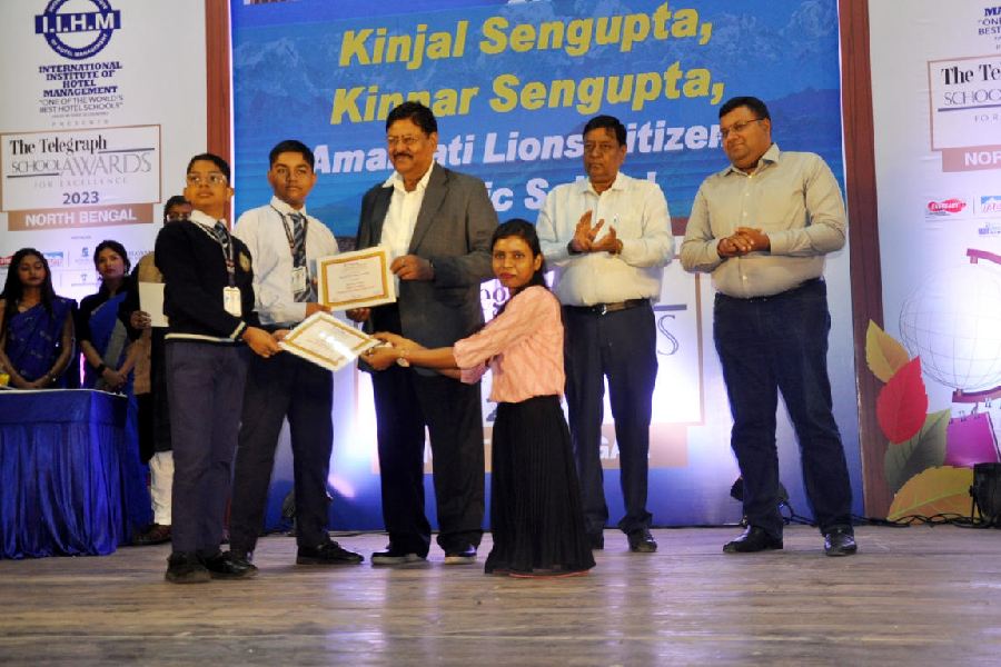 Kinnar and Kinjal Sengupta, who are brothers and students of Amarpati Lions Citizens Public School, Siliguri, being handed over The PCM Group Award for Courage by PCM Group chairman Kamal Kumar Mittal and Puja Gupta at the first edition of IIHM presents The Telegraph School Awards for Excellence 2023 North Bengal in Siliguri on Tuesday. 