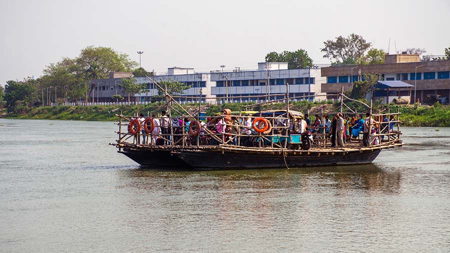 A boat ferries passengers and totos across the Bhagirathi river in Murshidabad 