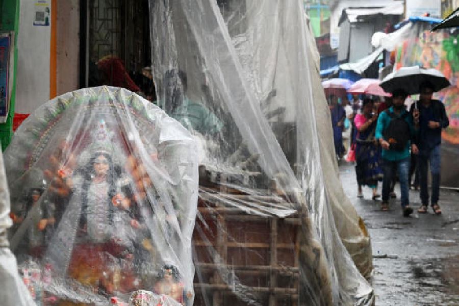 Durga puja idols covered in plastic amid rain in Kumartuli on Wednesday afternoon