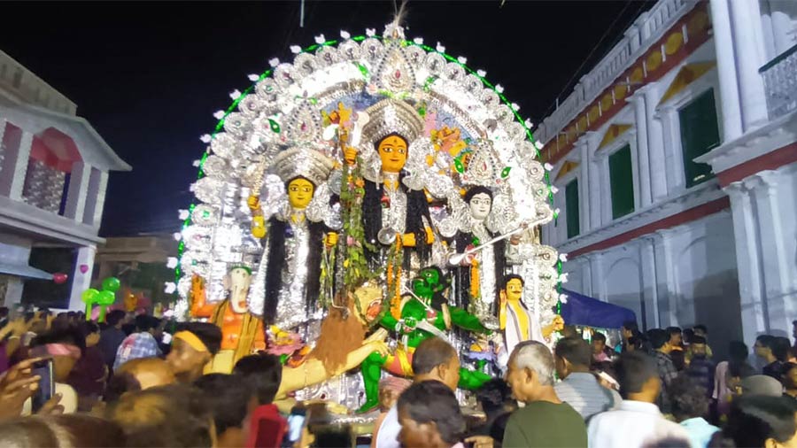 A crowd of devotees and family members accompany Surul Sarkar Bari’s ‘baro taraf’ deity for her immersion on Dashami