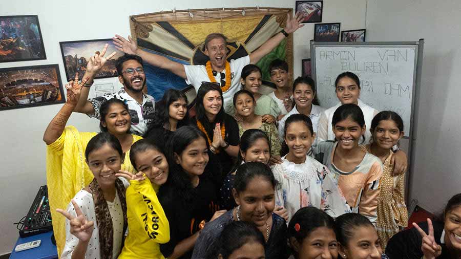 Armin van Buuren (with arms outstretched) and Laura van Dam (in namaste pose) interact with children at Ek Tara Foundation in Topsia