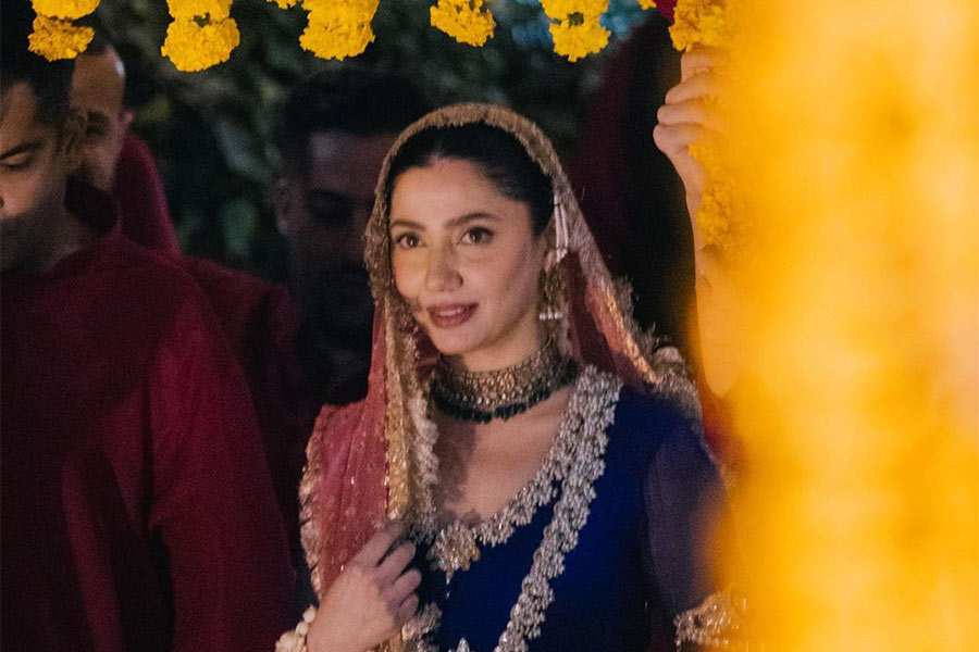 The actress walked down the aisle with a canopy of yellow marigold flowers.