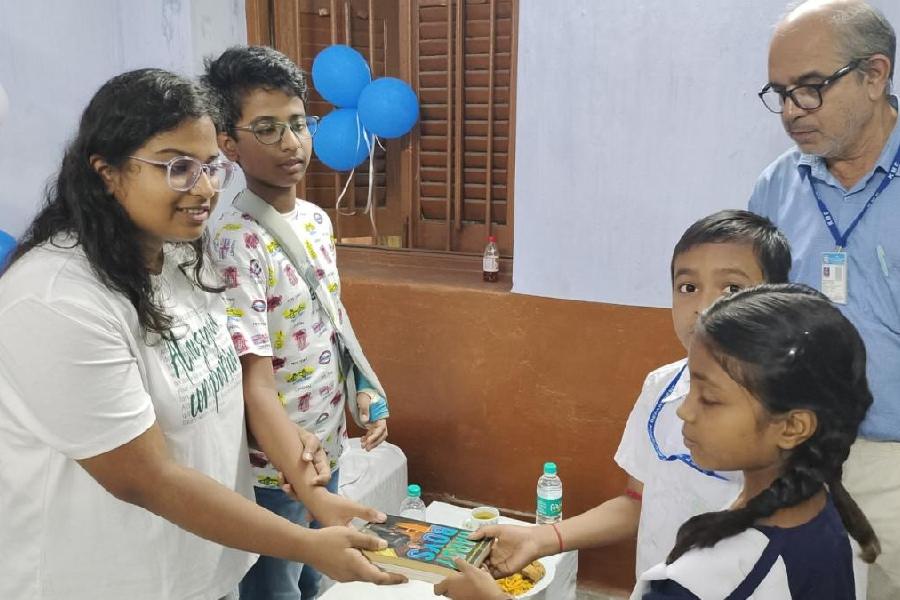 Ishi Singh and her brother Ayushmaan give books to children at a CMC school