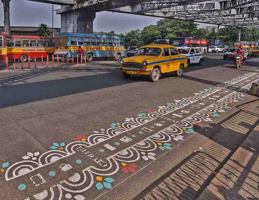 Ahead of Durga Puja, artists spruce up the sidelines of Howrah Bridge’s street with Alpona 