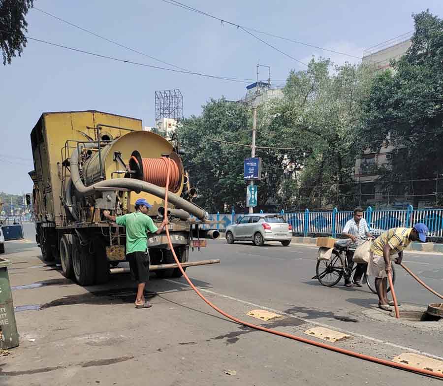 The Kolkata Municipal Corporation workers of the Solid Waste Management team cleared the manholes to fight waterlogging   
