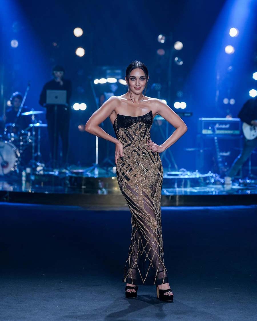 Kiara Advani looked gorgeous in a strapless black gown with golden decoration and a see-through fabric towards the bottom created by bridal collection label Falguni Shane Peacock. She opted for bold winged eyes, cherry-coloured lips and black platform heels.