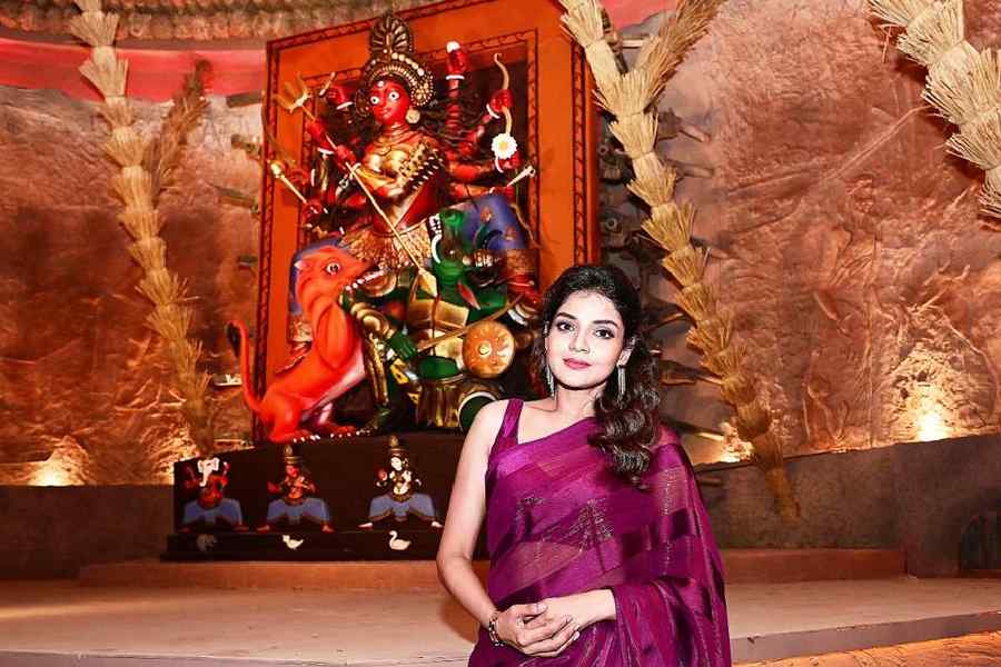 Arunima Ghosh posed in front of the beautiful Durga idol designed in an ancient style and painted by Parbati Das Baul
