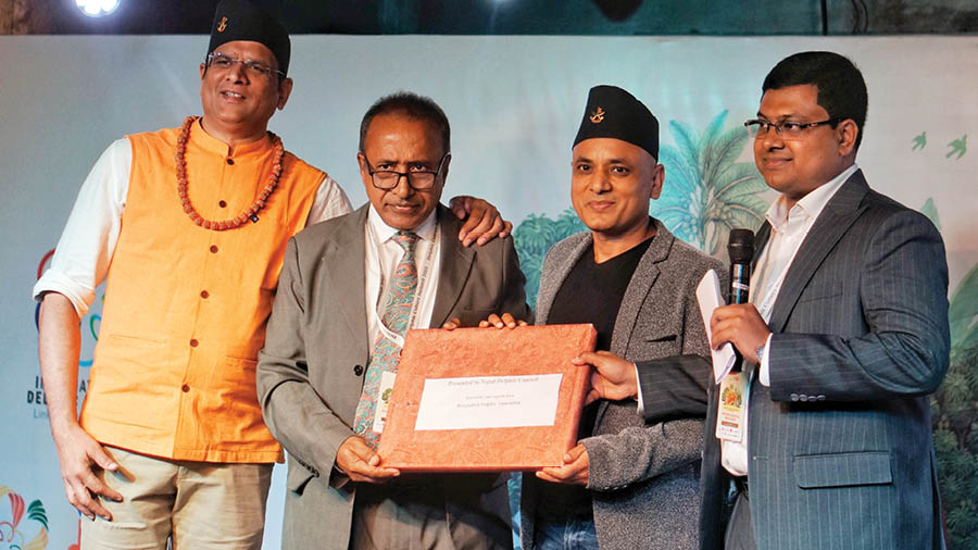 In the spirit of unity, (second from left) Mihir Kanti Choudhury of the Bangladesh Delphic Council presented a token of appreciation to (third from left) filmmaker B.L. Sridev, president of the Nepal Delphic Council (NDC)