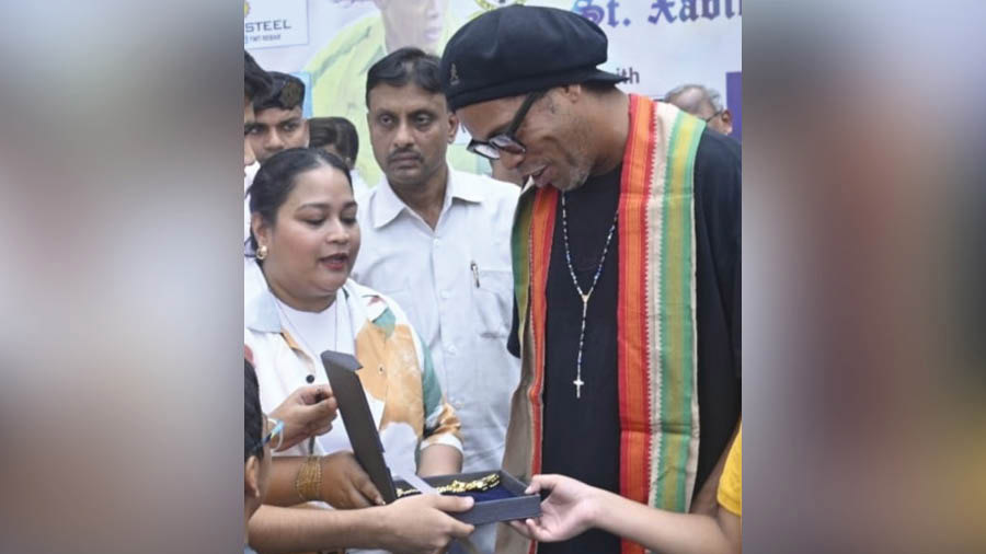 Ronaldinho receiving a special gold-plated silver chain from Senco Gold