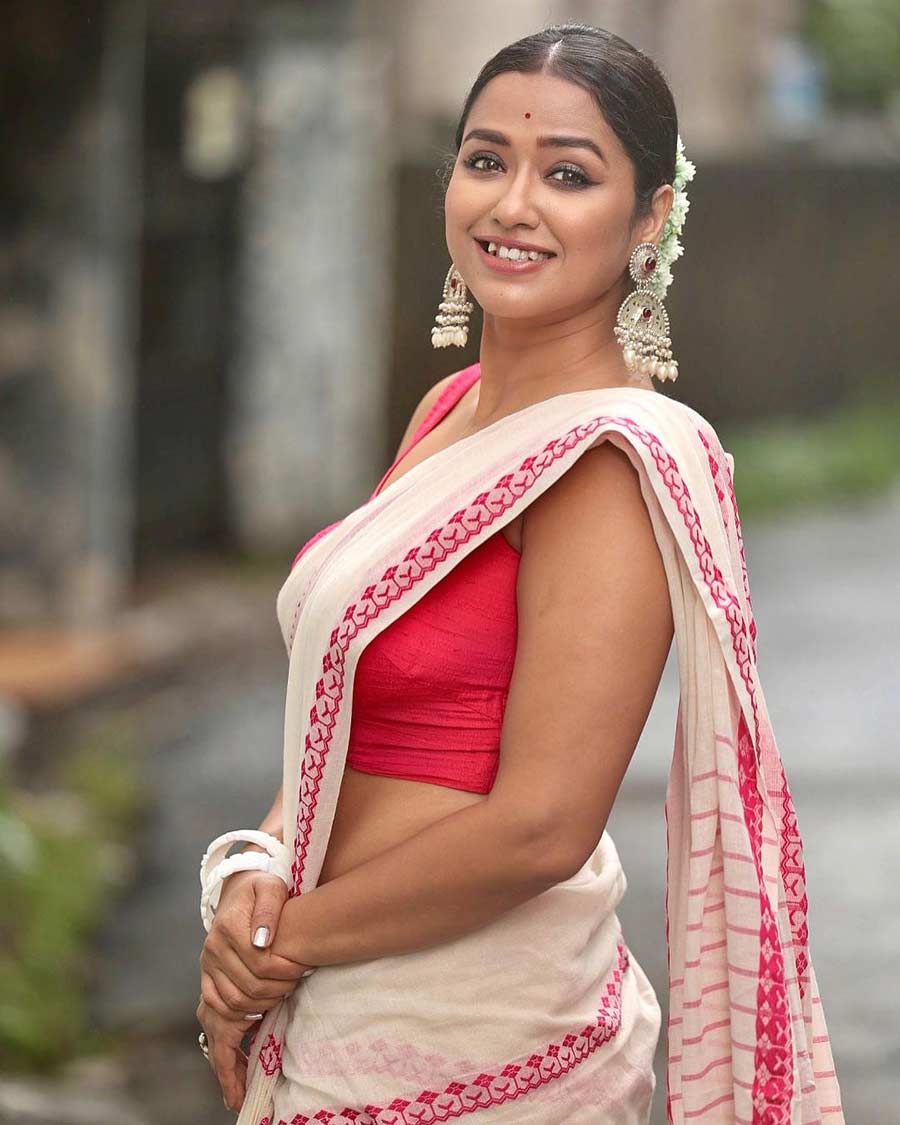 Sohini Sarkar shows how to jazz up the traditional white cotton sari with a red border. Oversized silver danglers and a neat bun wrapped in a mala make for a perfect pairing. 