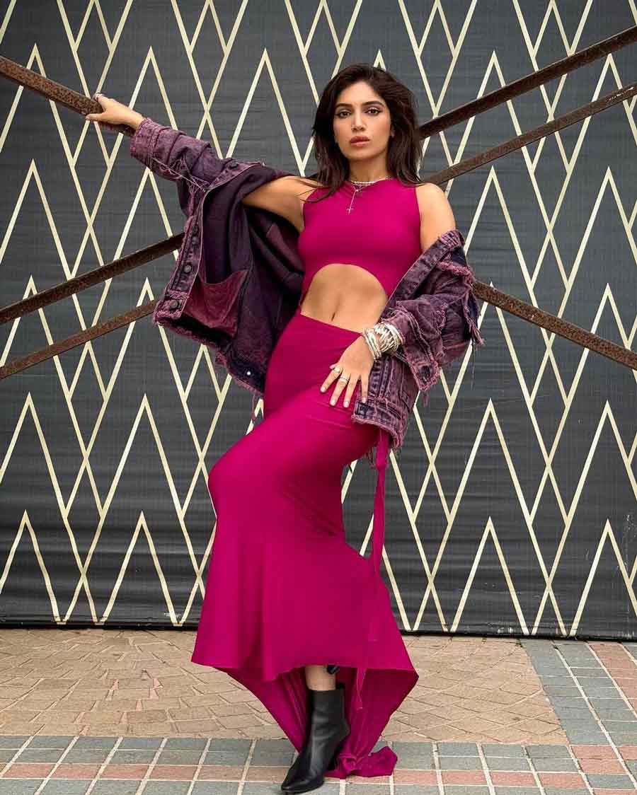 Bhumi Pednekar rocks a burgundy pink halter-neck cutout dress with an oversized denim jacket and dainty jewellery.