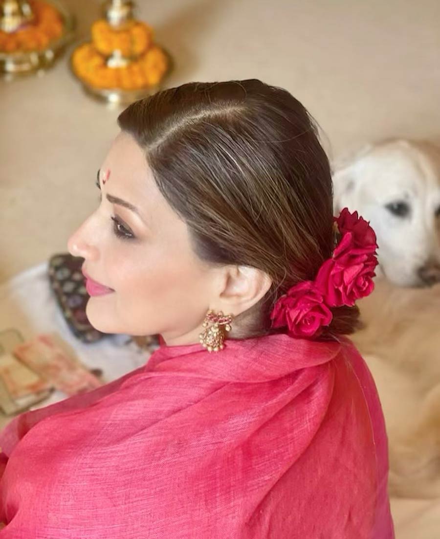 For some drama, tie your hair into a low bun and pin some rani pink roses like Sonali Bendre. Though Sonali’s sari shade matches the flowers, you can go for a sari of any colour. 