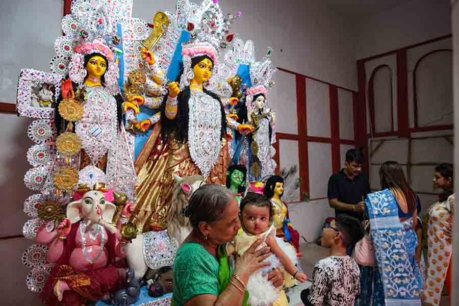 In this timeless celebration of 415 years, generations converge with unwavering devotion in Behala’s Barisha on the southwestern fringes of Kolkata. As the elders encircle the adorned Durga Maa, guiding the children in placing her sacred weapons, the house resonates with the echoes of tradition