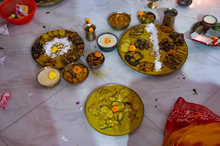 The family delicately prepares and serves the ‘bodhon bhog’ offering to Ma Durga via the priest