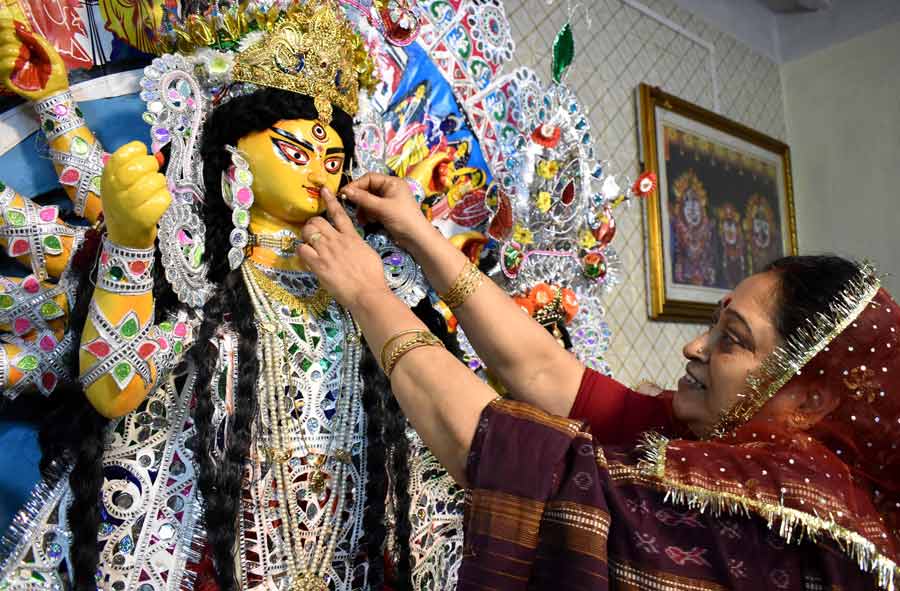 A woman at the Bonedi Haldar House at north Kolkata putting a “nath” on the idol of Goddess Durga as part of the “bodhon” rituals on Sasthi  