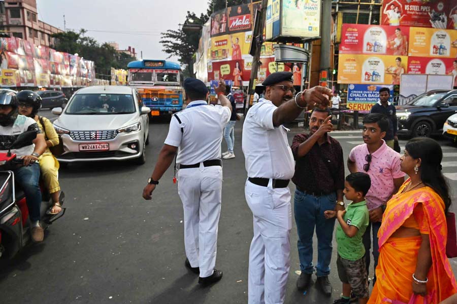 Kolkata Traffic Police sergeants guide pandal-hoppers at the Manicktala crossing on Saptami afternoon