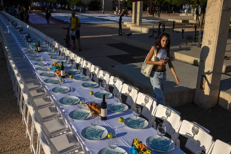A long table that was set up as part of a demonstration, with 203 empty places, one for each hostage believed to be held in Gaza, before Shabbat in Tel Aviv, Israel, Oct. 20, 2023. Hamas has released two American hostages, but concern is rising about the hundreds still held in Gaza, especially the injured and ill.