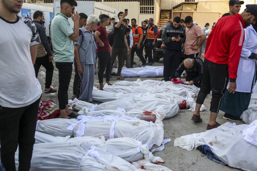 Mourners place the bodies of relatives killed in Israeli airstrikes on Nuseirat and Deir al-Balah in Gaza, on Sunday, Oct. 22, 2023.