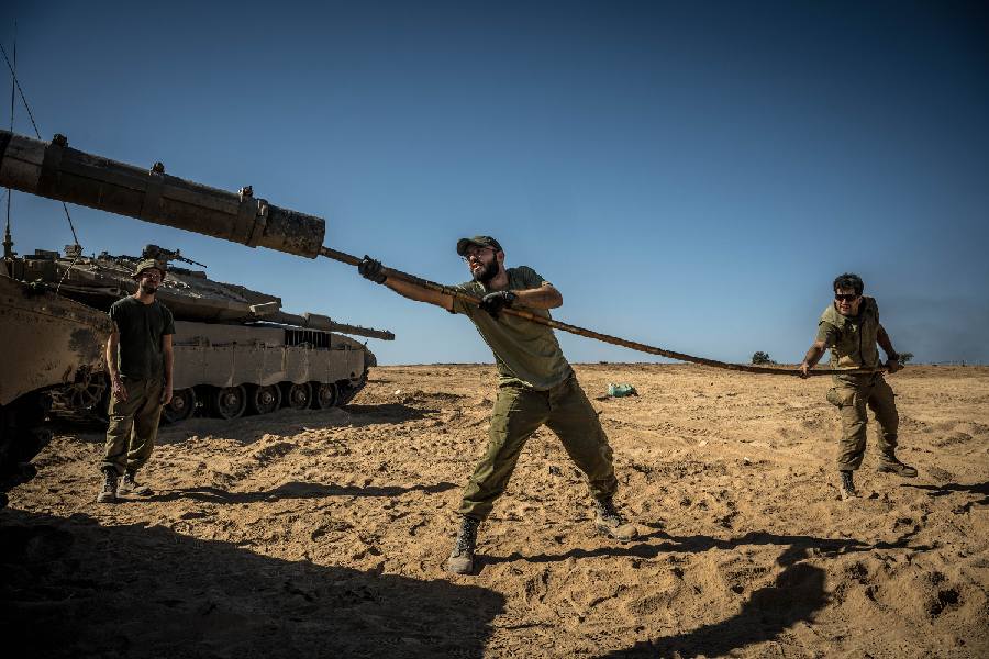 Israeli soldiers clean the barrel of the tank outside Be'eri, Israel, on Saturday, Oct. 21, 2023. Violence on Israel’s northern border with Lebanon, and strikes in Syria and the West Bank, sent shock waves through the Middle East.