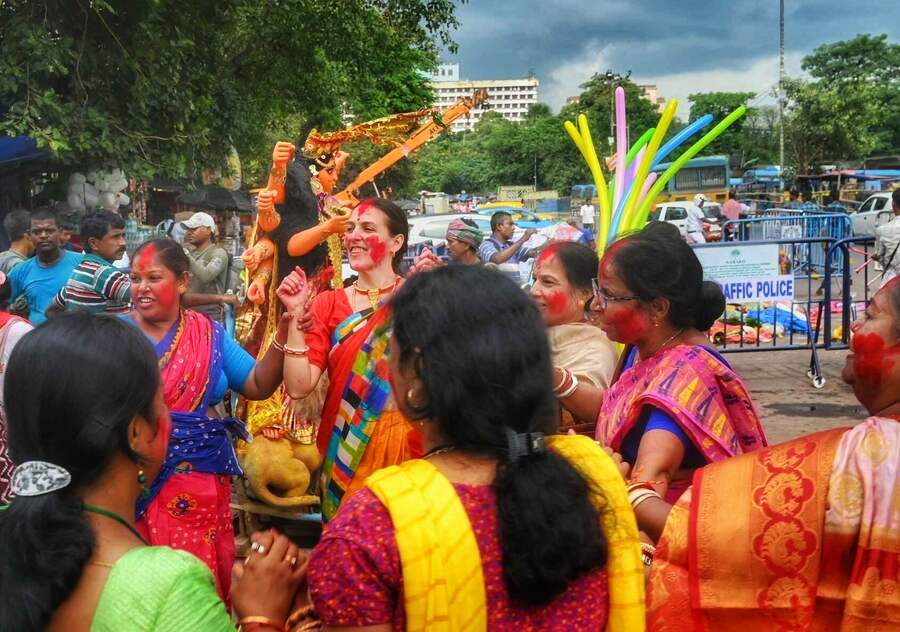 Several women engaged in ‘sindoor khela’ applying the sacred vermilion on each other 