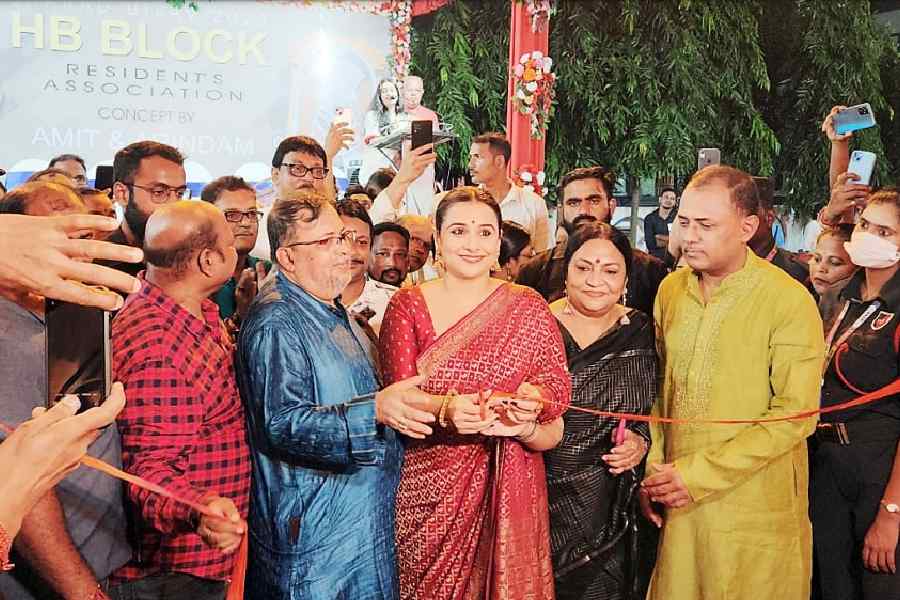 Vidya Balan cuts the ribbon at HB Block’s puja with director Goutam Halder on her right
