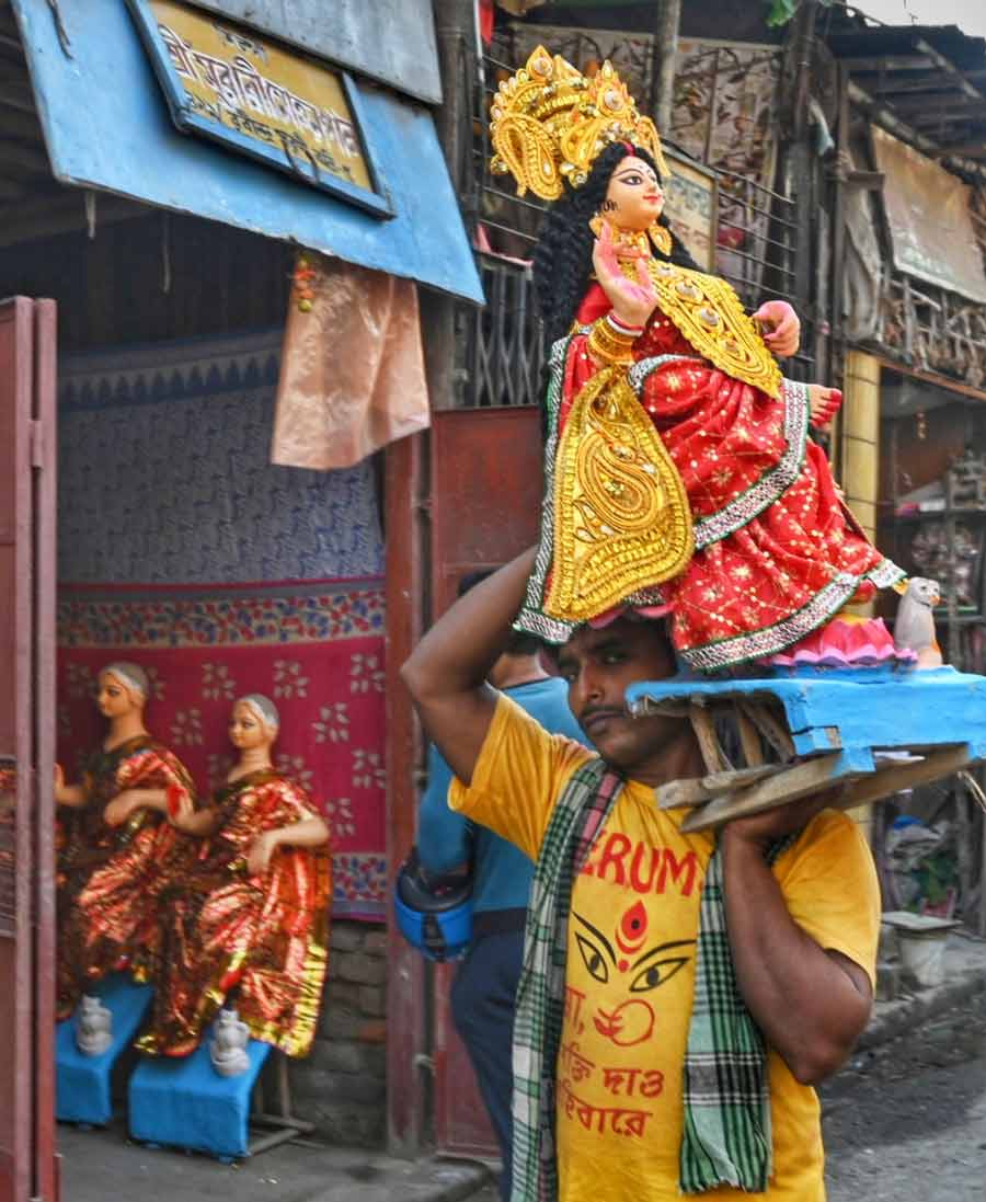 A porter carries an idol of Lakshmi from one of the studios in Kumartuli