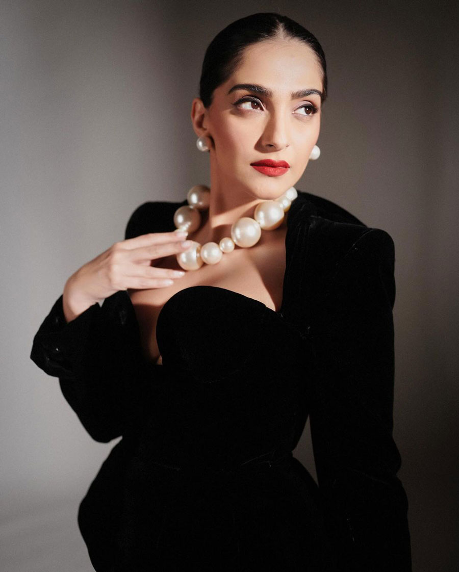 Sonam Kapoor donned a black midi dress coupled with a matching hat and a pearl necklace. 