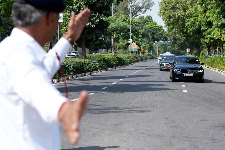 A traffic police official regulate the movement of a convoy near Pragati Maidan