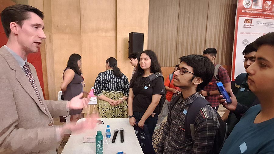 (Left) Consular officer Dane Rohrer interacts with students about their visa applications