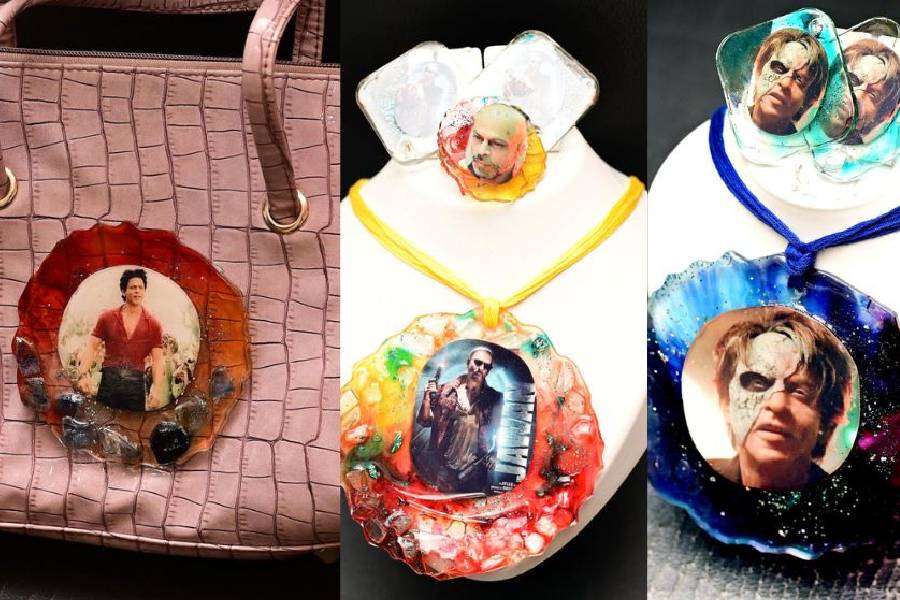 (From left) A bag adorned with Shah Rukh Khan’s look in Jawan and Jawan-themed pendants and earrings