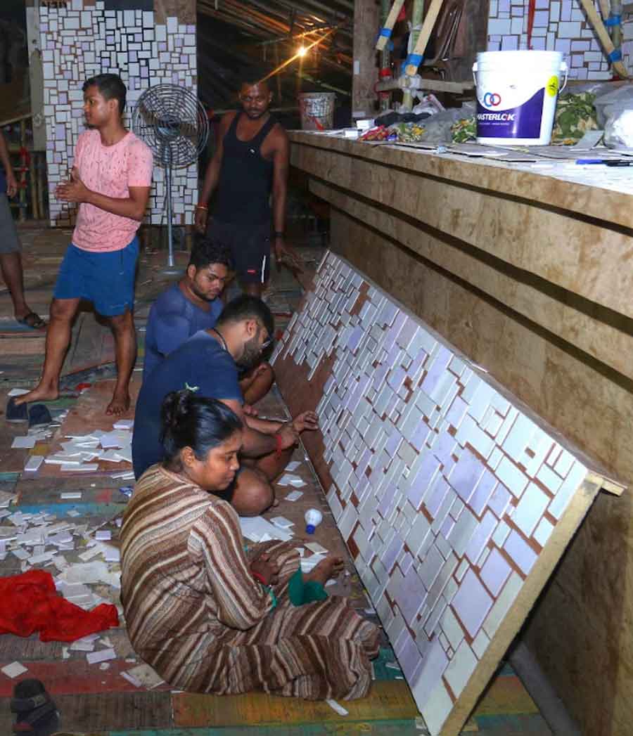 Art college students busy at work at a Durga Puja pandal in Jagat Mukherjee Park, north Kolkata, on Friday  