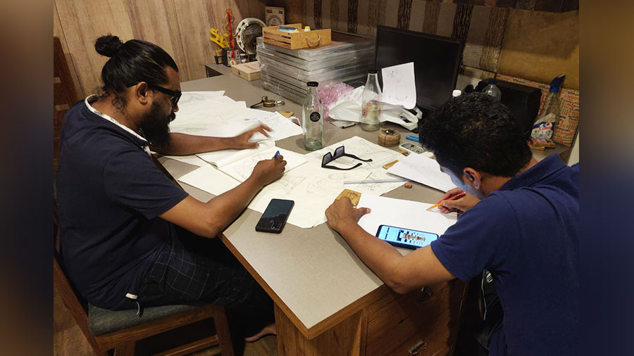 SK Tanjilur Rahaman Hemal (left) at the drawing table planning the Durga Puja artwork